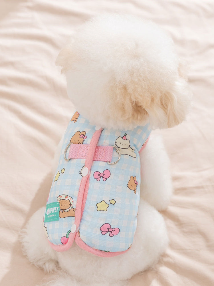 Rear view of a white poodle wearing a light blue gingham dog vest with cartoon bears and strawberries