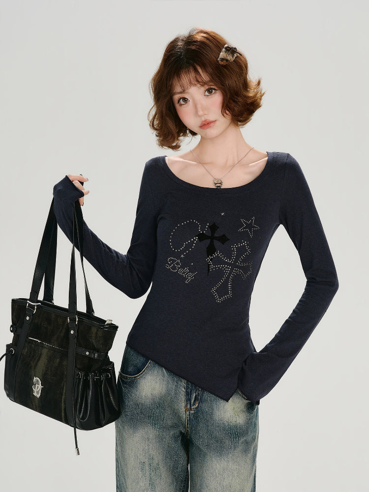 Woman wearing a dark blue long-sleeve top with a scoop neckline and flared cuffs, styled with denim jeans and a black bag.