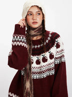 Close-up of a woman wearing a maroon and white knit sweater with an apple Fair Isle pattern, showing the texture of the knit and the details of the pattern.