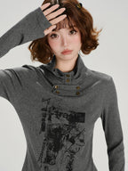 Close-up of a woman wearing a grey long-sleeve graphic print turtleneck top with button detailing at the neckline.