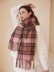 Model wearing a pink and brown plaid scarf with fringe