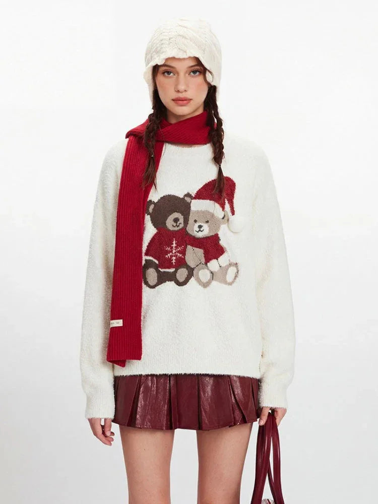 Close-up of a white fuzzy knit sweater with a graphic of two teddy bears wearing Christmas hats.