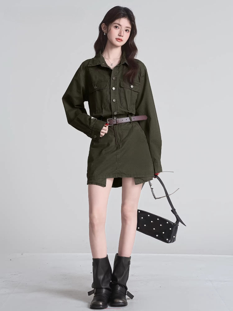 Woman in a green shirt and skirt set, black boots, and black handbag, holding sunglasses