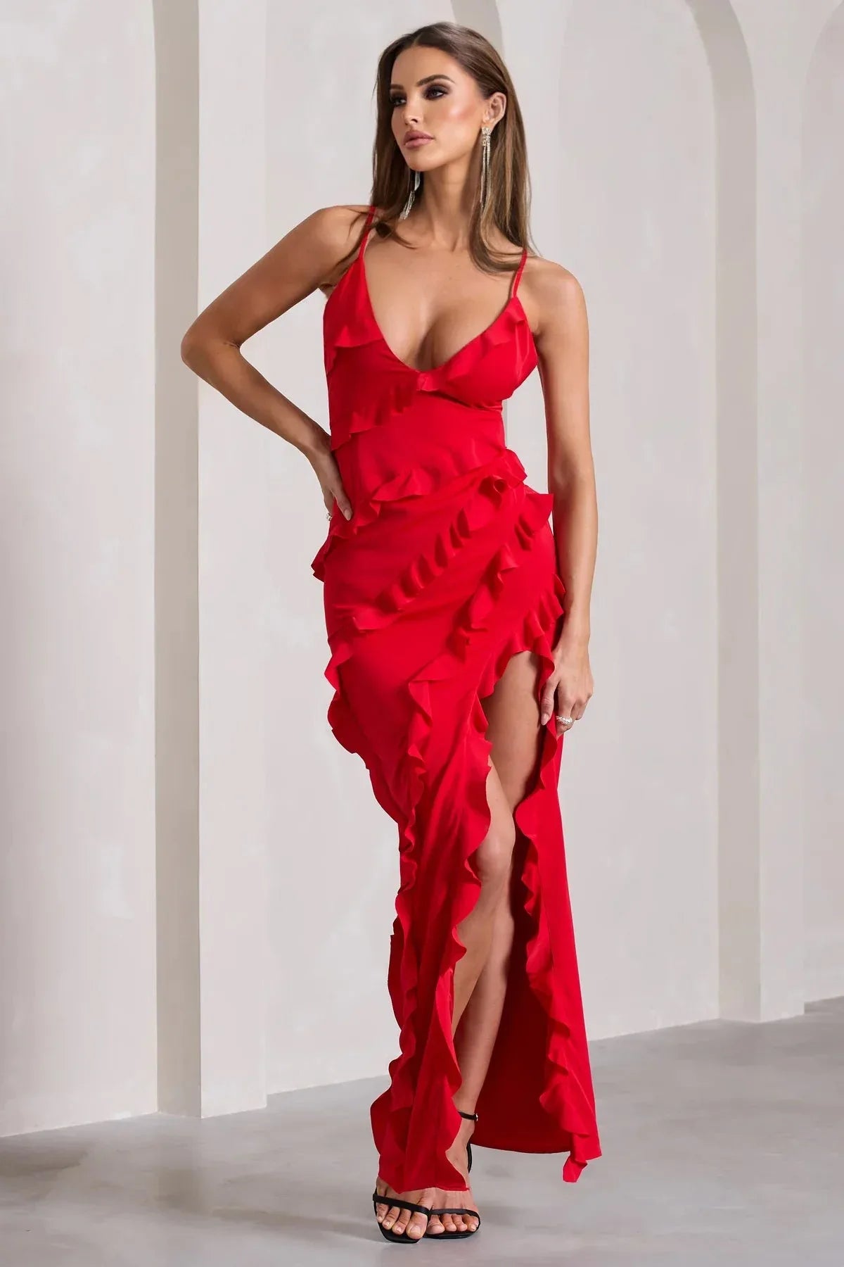 woman posing in a red evening gown with a thigh-high slit