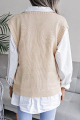 Back view of a woman wearing a cream knit V-neck sleeveless vest over a white collared shirt.