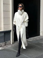 Woman wearing a white oversized wool blend coat with black leather gloves and boots