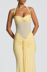 Close-up of the bodice and skirt of a pale yellow floor-length halter gown