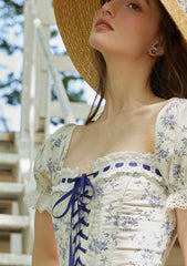 Detail of the lace-up bodice on a floral print midi dress.
