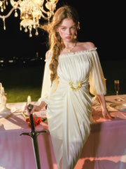 Model showcasing a formal cream satin dress with an off-the-shoulder neckline and intricate gold embellishment at the waist.