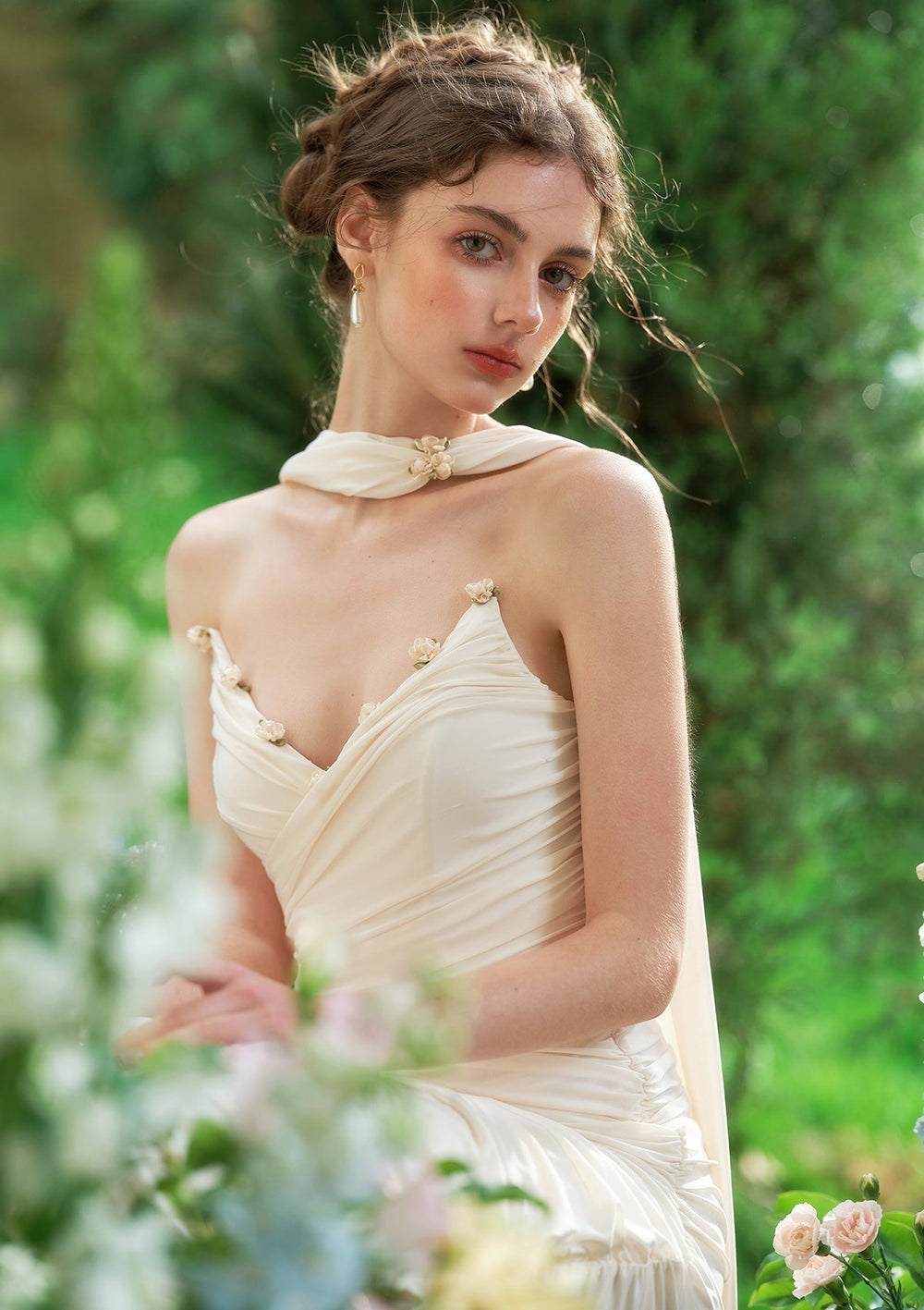 Detail shot of the floral embellishments on the bodice of a cream satin formal dress.