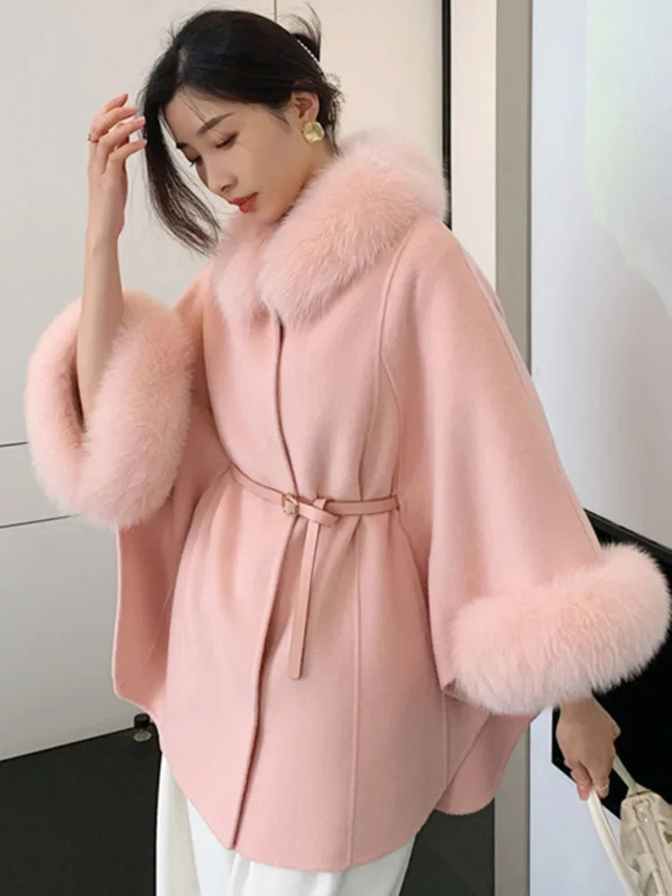 Light pink wool blend cape with fur collar and cuffs, cinched with a belt, worn by a person