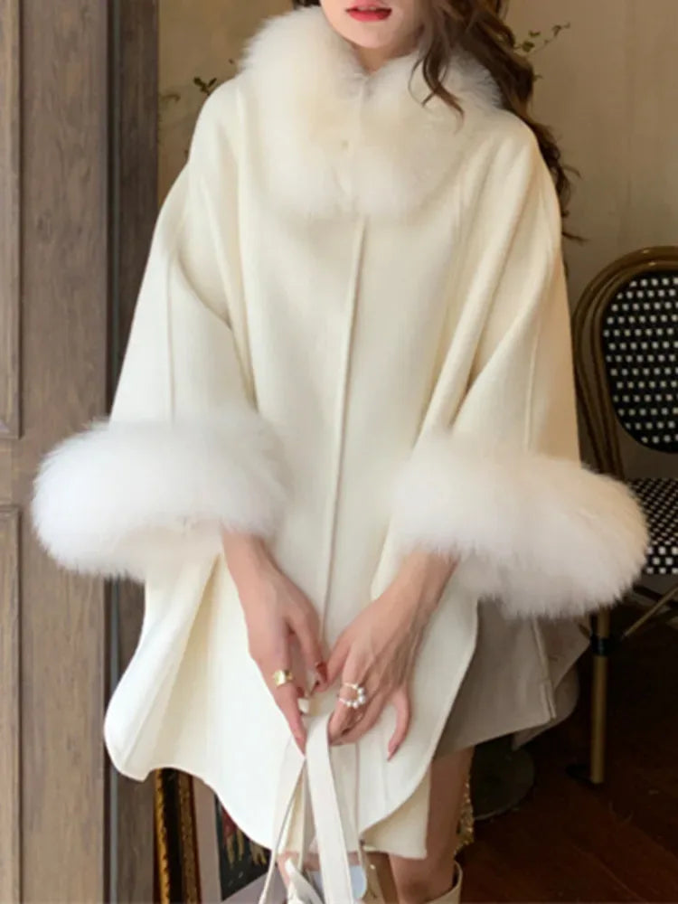 Cream wool blend cape with fur collar and cuffs worn by a person Main image