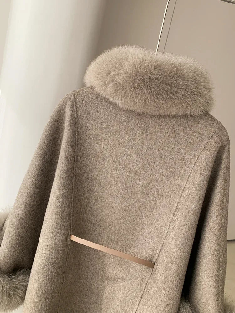 Close-up of the back of a light grey wool blend cape with fur collar and belt detail
