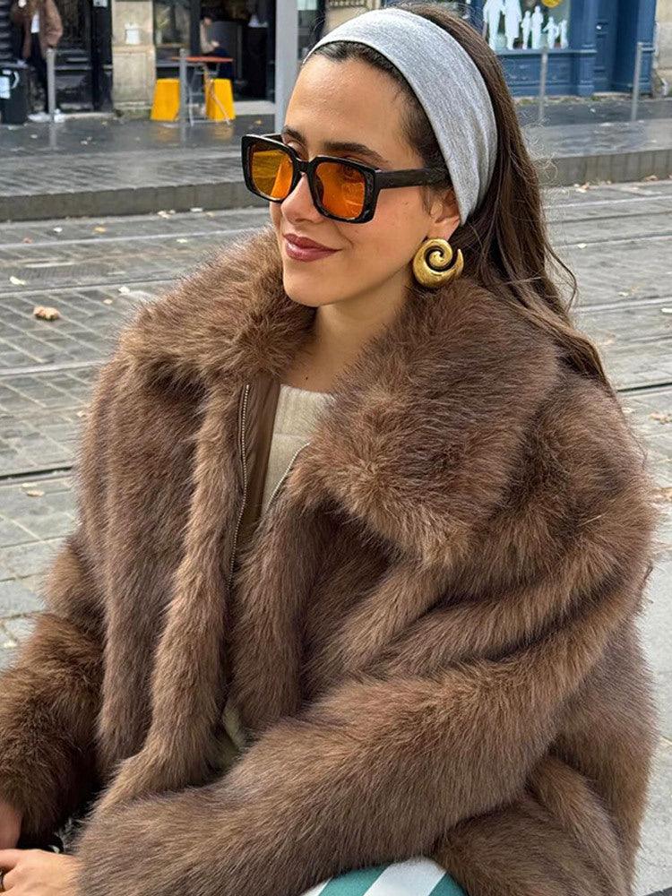 close-up of a woman wearing a brown faux fur jacket and large earrings