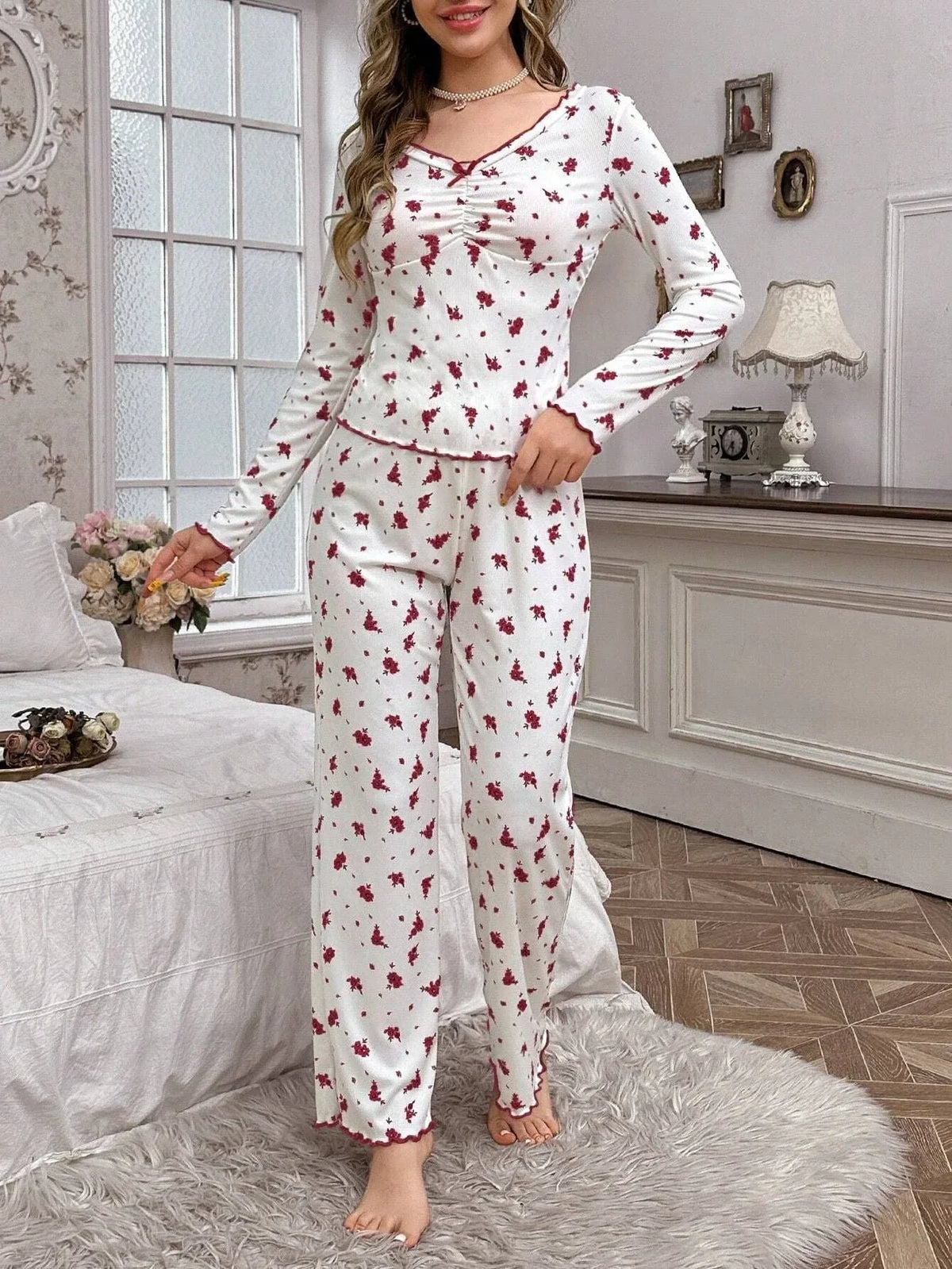 Woman wearing white floral print pajamas standing in a bedroom Main image