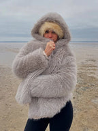Woman wearing a grey faux fur hooded coat outdoors