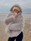 Woman wearing a grey faux fur hooded coat outdoors