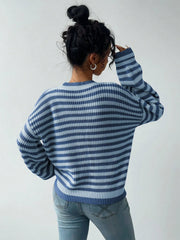 Back view of a woman wearing a blue and light blue striped knit sweater and light wash jeans.