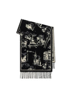 A folded black and white patterned scarf with a city landscape print and fringed edges