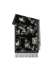 A folded black and white patterned scarf with a city landscape print and fringed edges