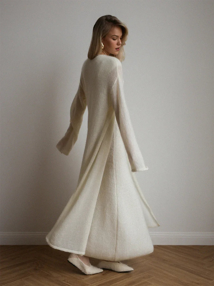 Back view of a woman wearing a long white ribbed knit dress with a matching flowing cardigan.