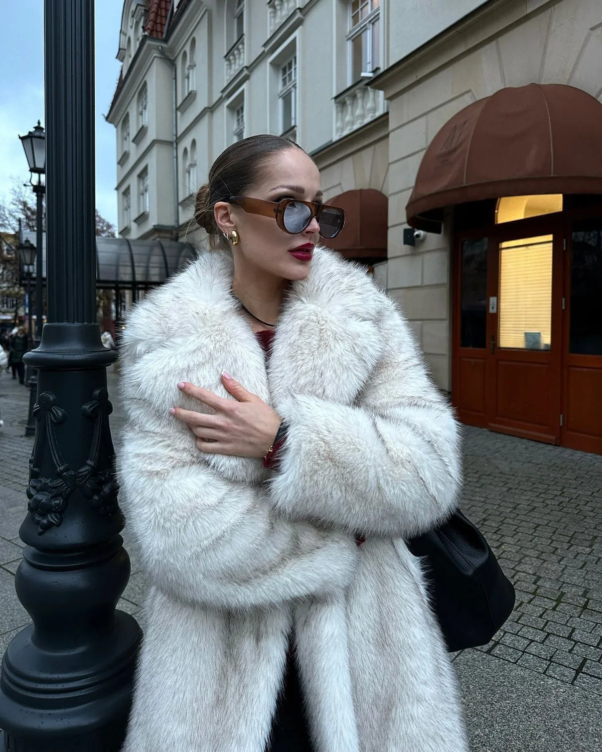 Woman wearing a white faux fur coat Main image