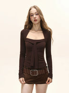 Front view of a woman wearing a brown long-sleeved top with a square neckline and bow detail, and brown shorts.