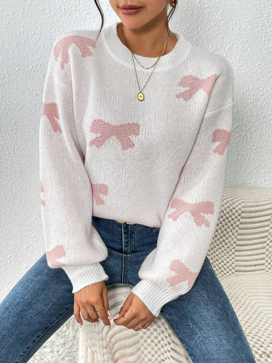 Woman wearing a white crew neck sweater with pink bow print and blue jeans