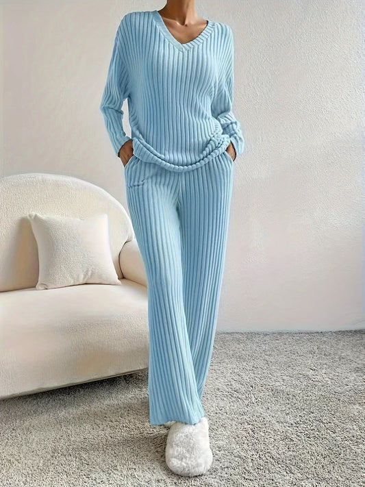 Woman standing in a light blue ribbed loungewear set with white slippers
