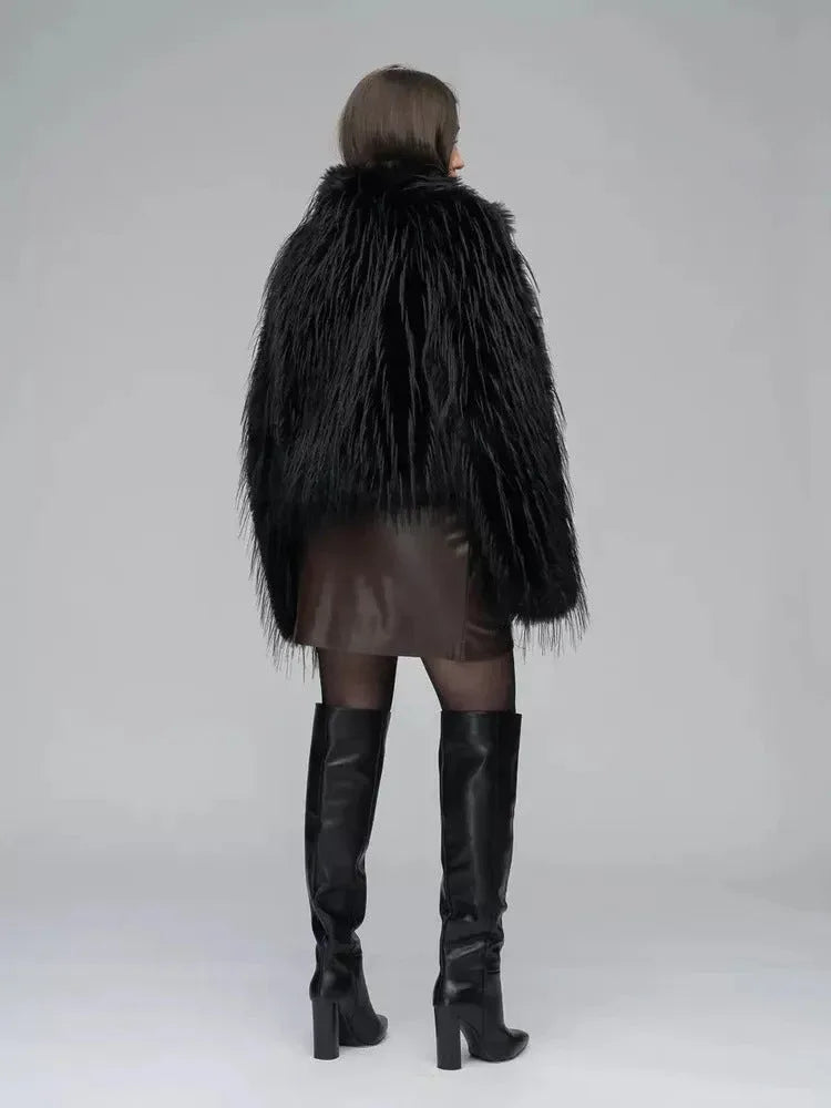 Back view of a woman in a black faux fur jacket, brown wrap dress, sheer black tights, and black knee-high boots.