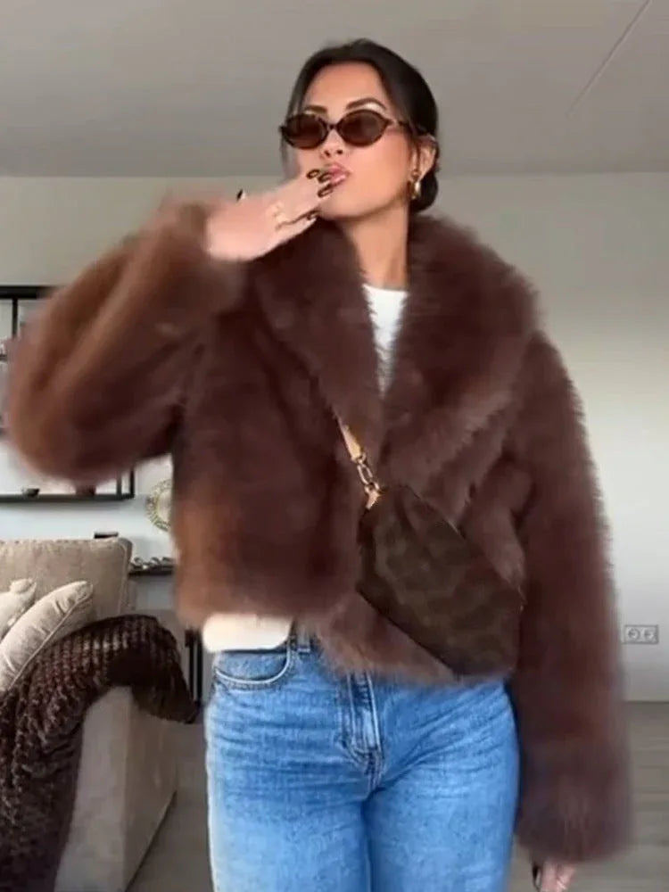 woman wearing a brown faux fur jacket with sunglasses and jeans, posing indoors