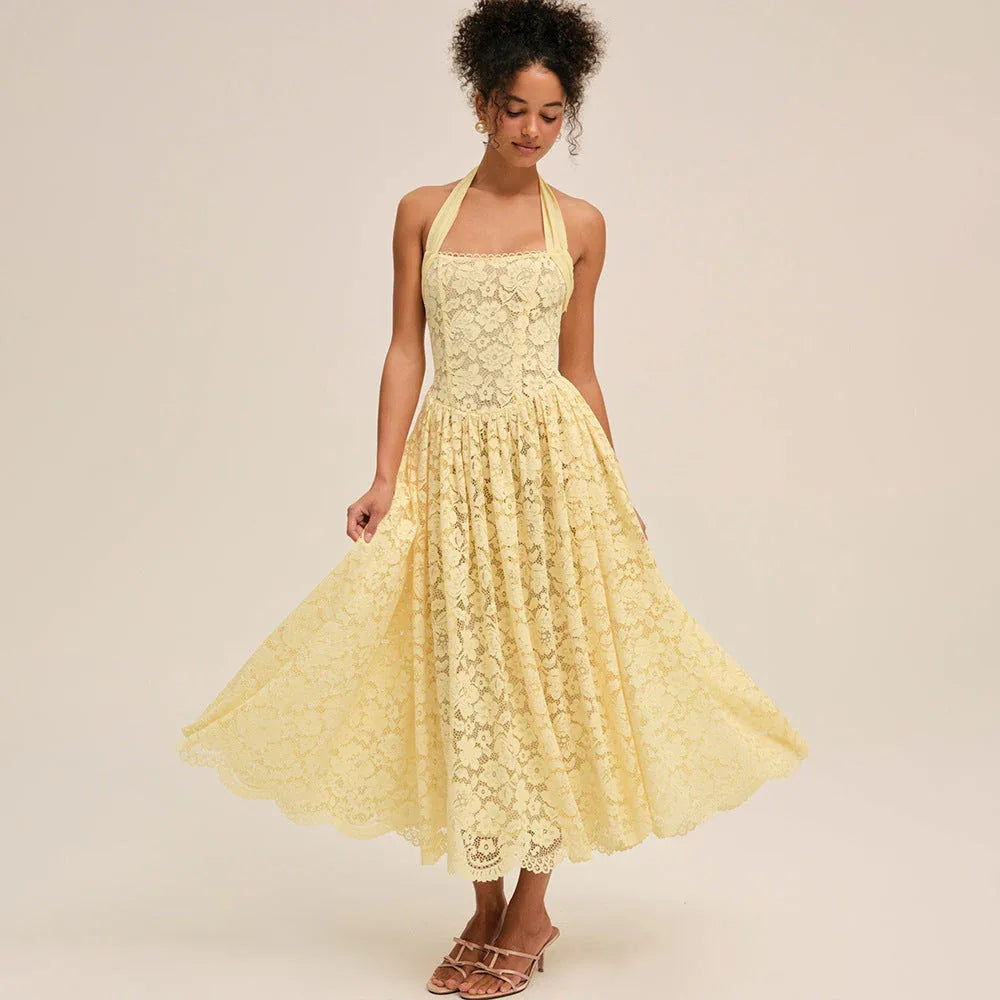 Model twirling in a yellow lace halter midi dress