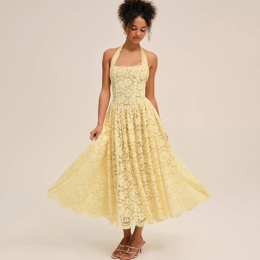 Model twirling in a yellow lace halter midi dress