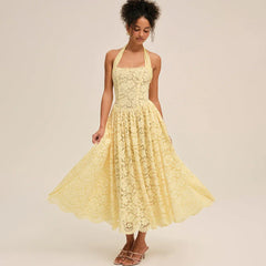 Model twirling in a yellow lace halter midi dress