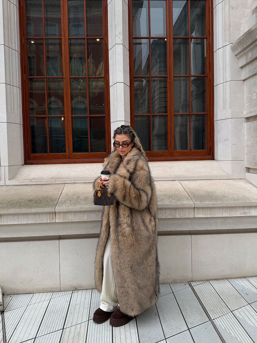 Full-length view of a woman in a long, plush faux fur coat with a lapel collar, paired with casual pants.