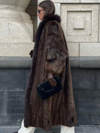 side profile of a woman showcasing the length and texture of a brown fur coat