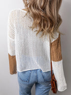 Back view of a woman wearing a color block knit sweater.
