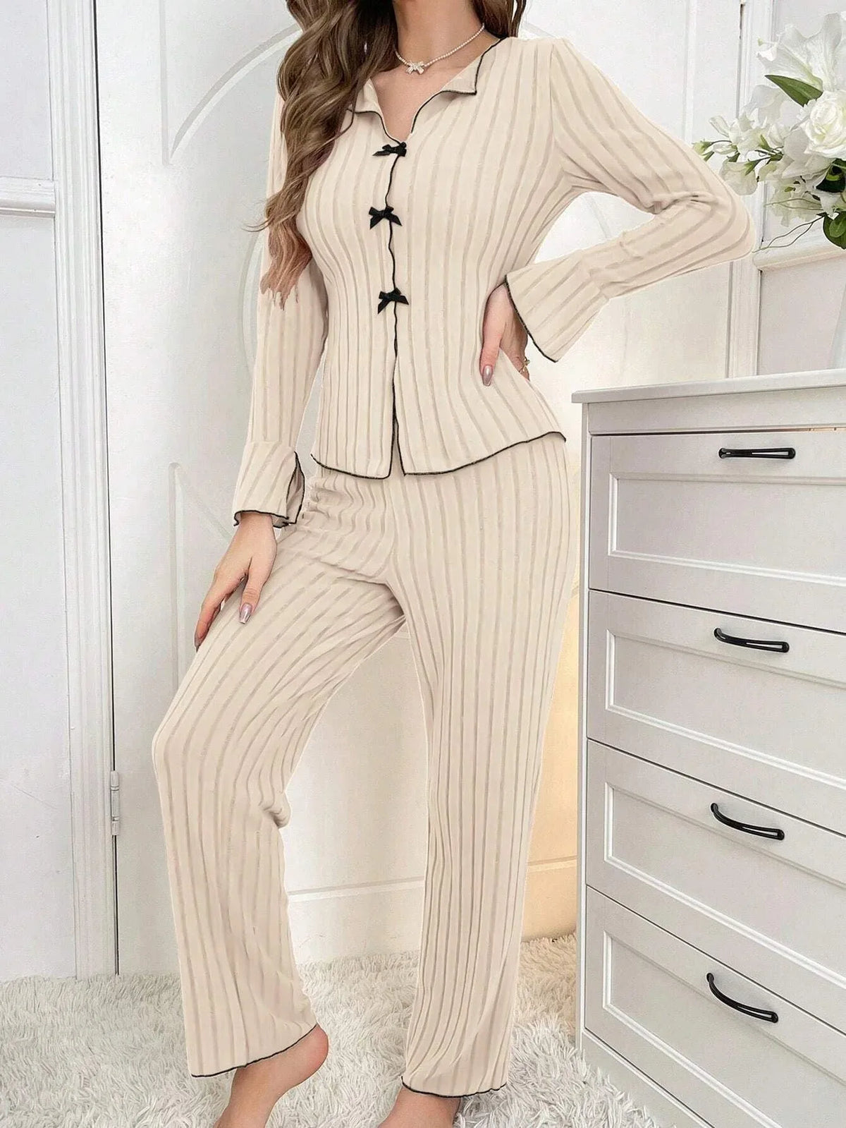 woman standing in cream ribbed knit pajama set with black trim and bows Main image