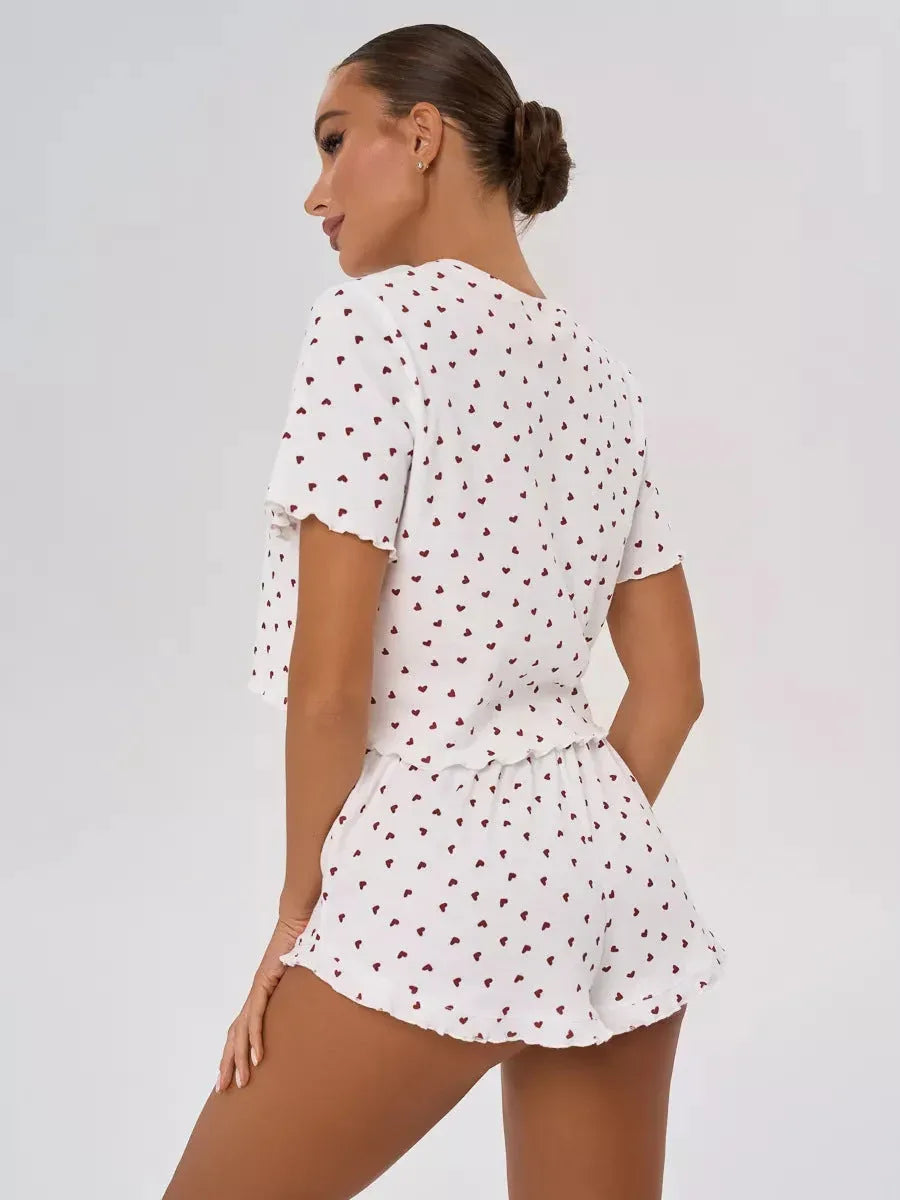 Woman wearing a white cropped t-shirt and shorts with a red heart print, viewed from the back.