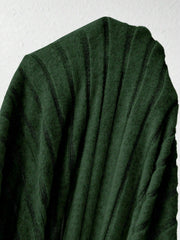 Close-up of the green ribbed knit fabric of a dress.