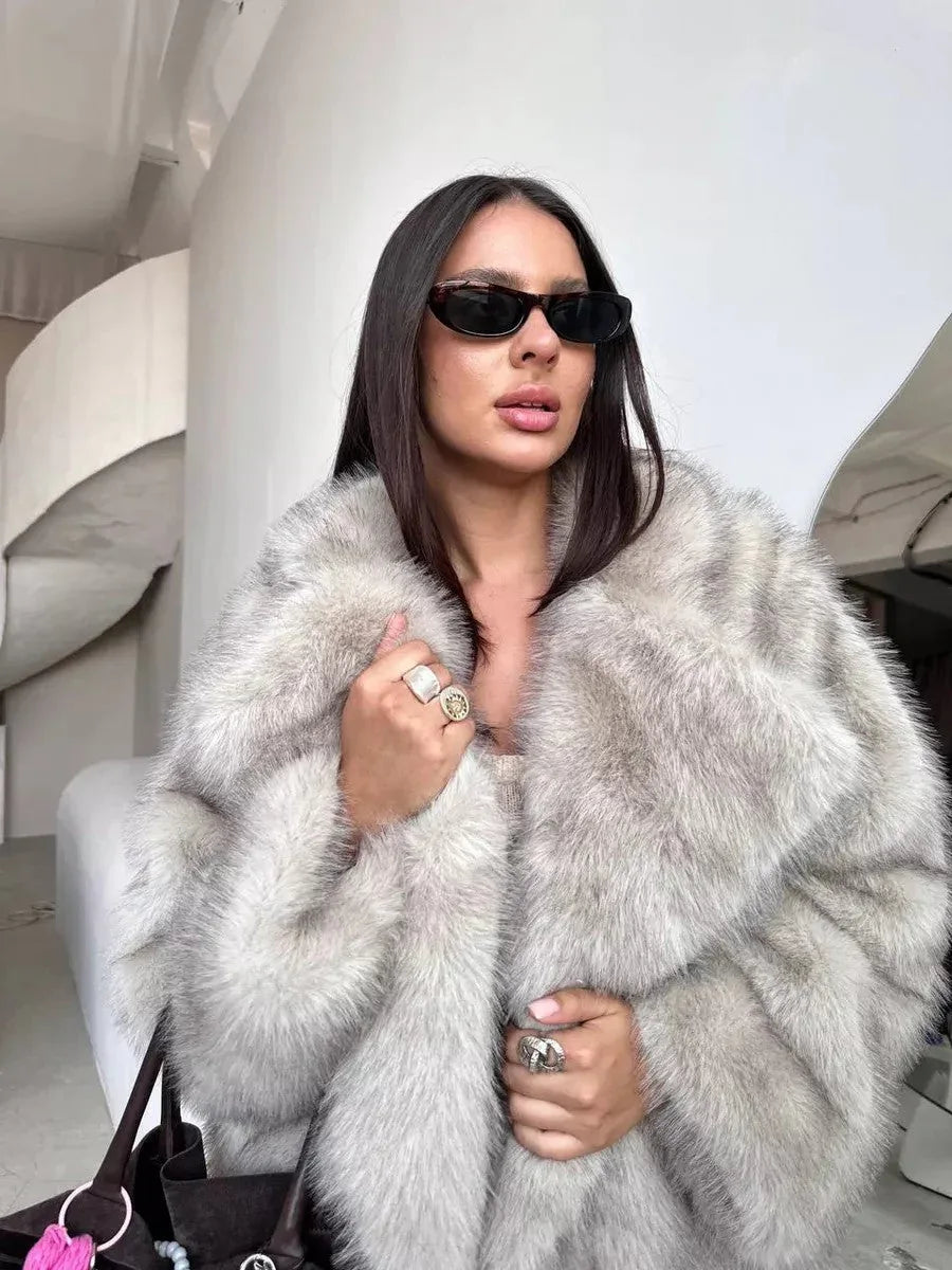 close-up of a woman wearing a light grey faux fur coat and rings