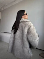 back view of a woman in a light grey faux fur coat