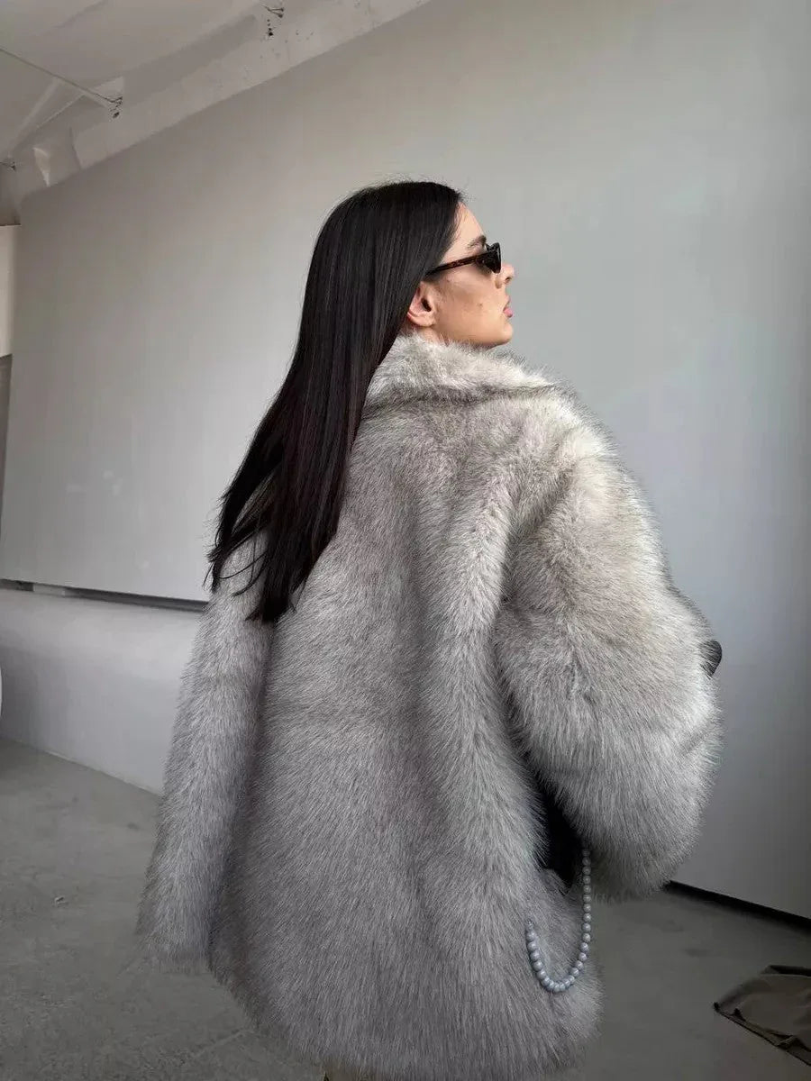 back view of a woman in a light grey faux fur coat