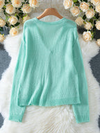 Back view of a light mint green mohair blend cardigan with a V-neck and ribbed hem.