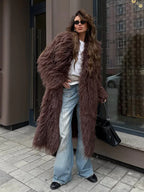 Full body shot of a woman in a long brown furry coat and wide-leg jeans