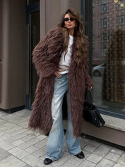 Full body shot of a woman in a long brown furry coat and wide-leg jeans