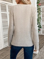 Back view of a woman wearing a cream ribbed long-sleeve crew neck top with dark wash jeans