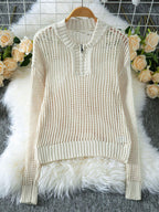 Cream open knit quarter-zip sweater displayed on a hanger with decorative roses.