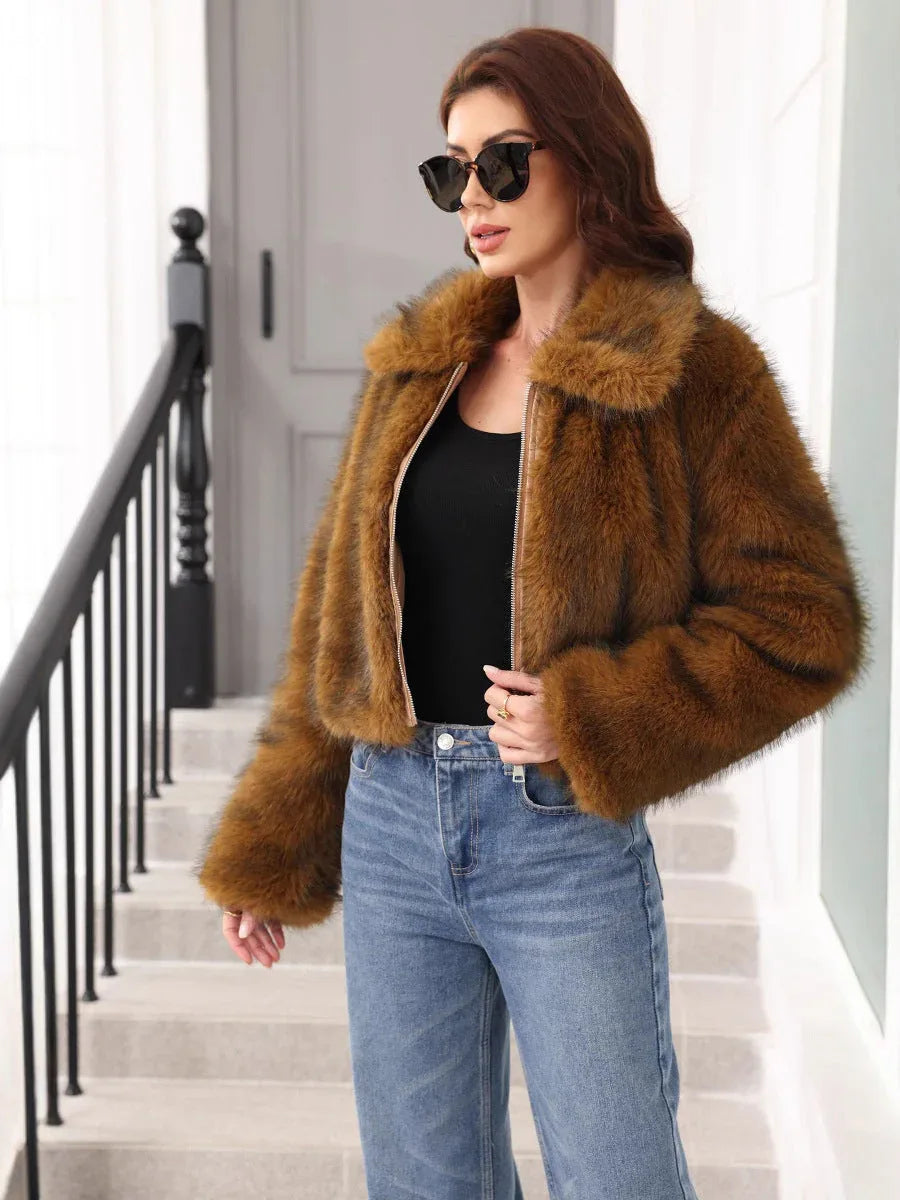 Woman wearing a brown faux fur cropped jacket over a black top and blue jeans, standing on stairs. Main image
