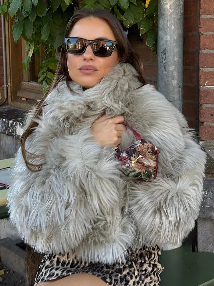 Woman wearing a shaggy faux fur jacket and leopard print skirt outdoors. Main image